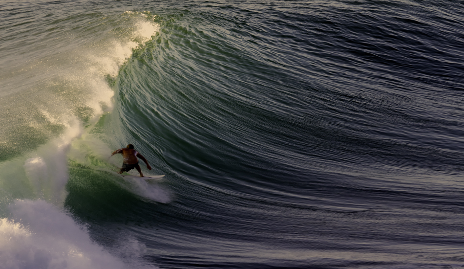 Peanut gallery view of Racetracks during the sunset session. Here, an unknown surfer reaps the rewards of patience and good timing.  Uluwatu, Bali